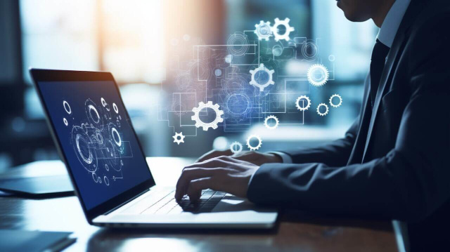 【兵庫で求める人材を集める求人媒体掲載】たくさんの歯車アイコンとパソコンを使う男性